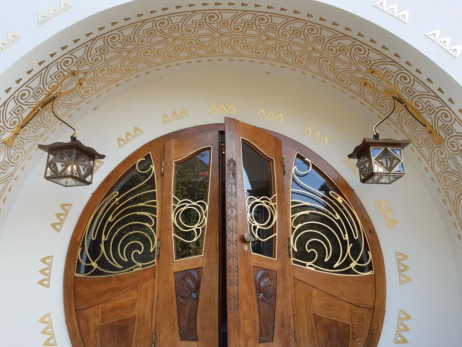 Restauriertes Eingangsportal des Haus Glückert mit vergoldeten Jugendstil-Ornamenten und Messing-Laternen